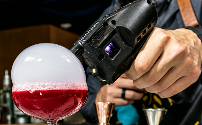Bulle de fumée aromatique posée sur un cocktail rouge
